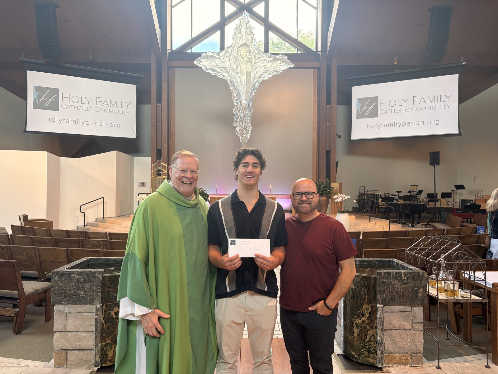 Erik Stanson receiving the Christifideles Award at Holy Family with Fr. Terry Keehan
